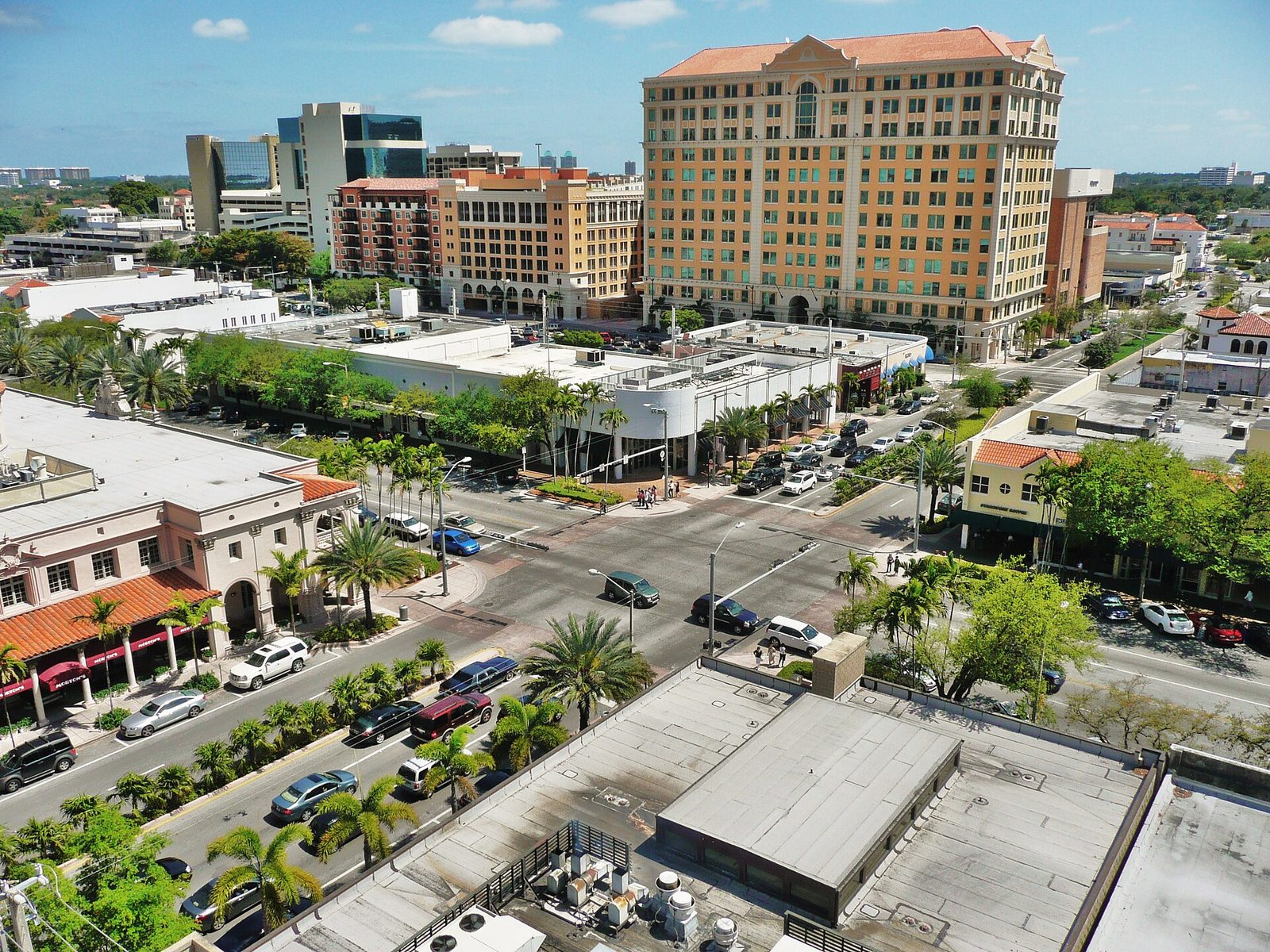 Aerial view over Miracle Mile and Coral Way in downtown Coral Gables — palm-lined streets and Mediterranean-style buildings