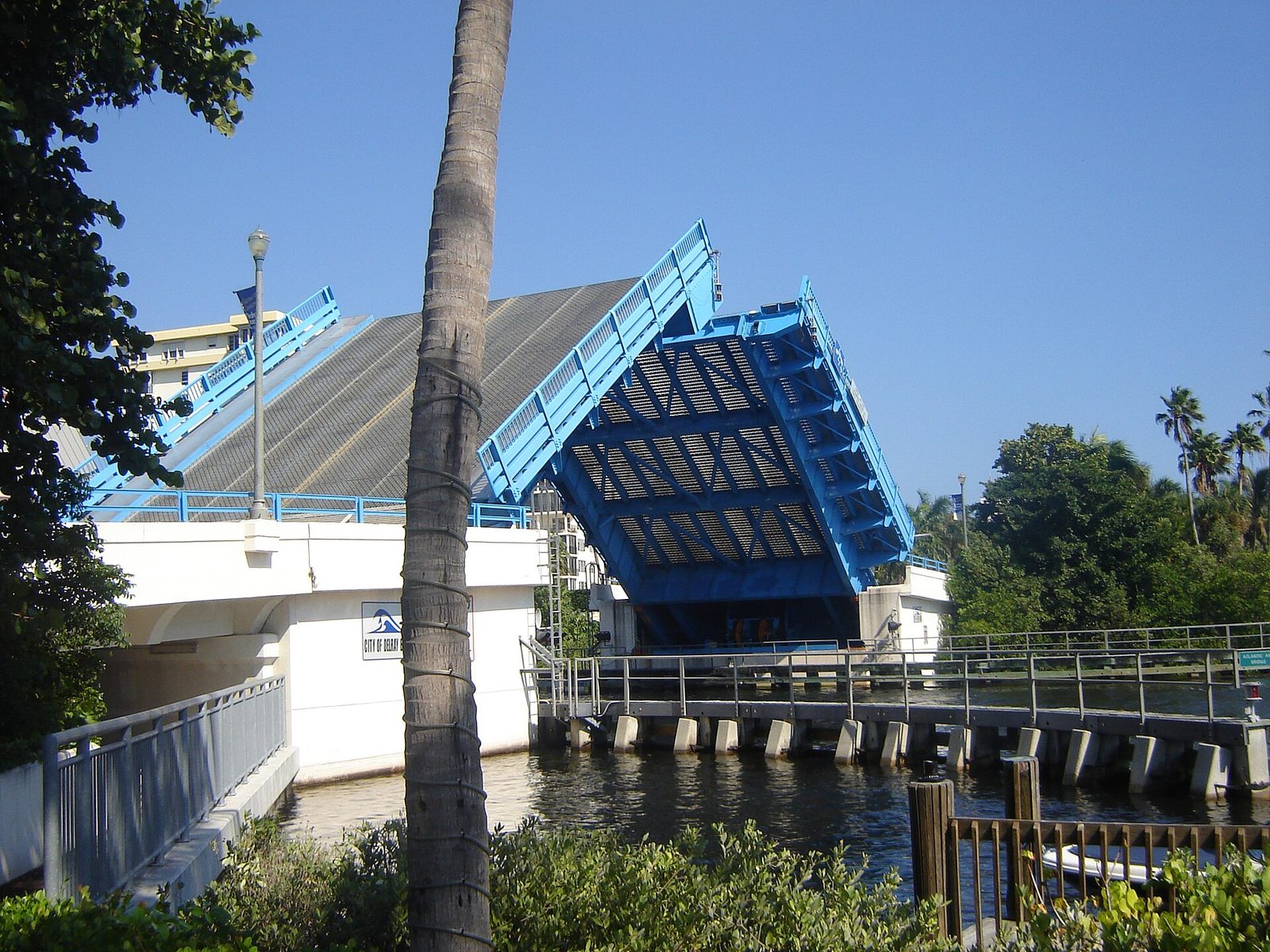 The blue Atlantic Avenue drawbridge raised over the Intracoastal Waterway in Delray Beach, Florida — the crossing between downtown and the beach