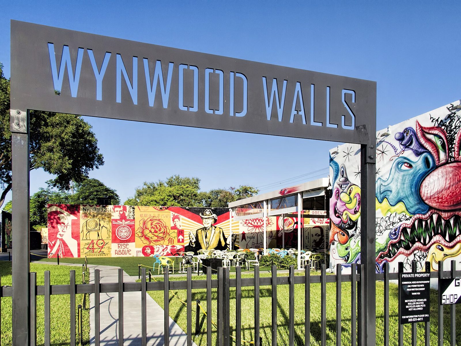 The Wynwood Walls entrance sign framing colorful murals inside the museum grounds in Miami