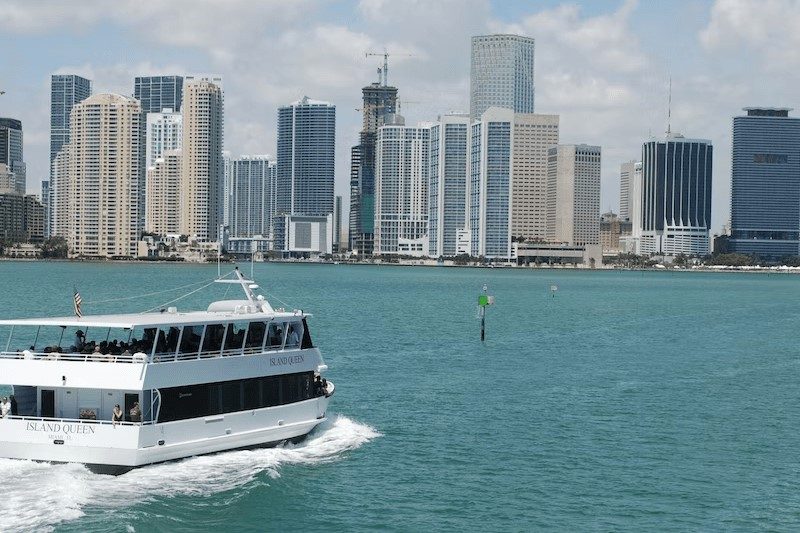 A sightseeing yacht cruising past the downtown Miami skyline from Bayside Marketplace