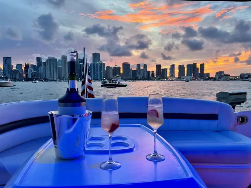 A private boat set with a champagne bucket and two glasses at sunset, Miami skyline behind