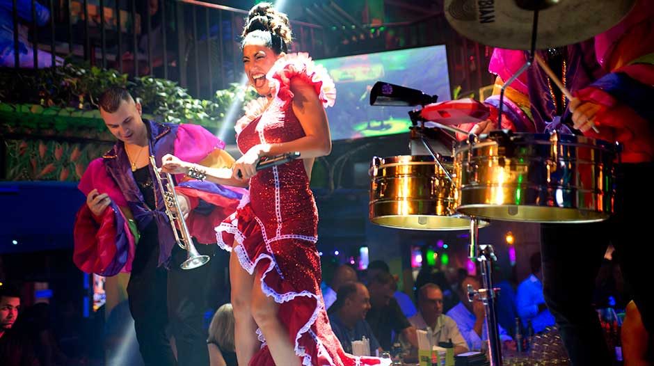 A dancer and live band performing on stage at Mango's Tropical Cafe, Miami Beach